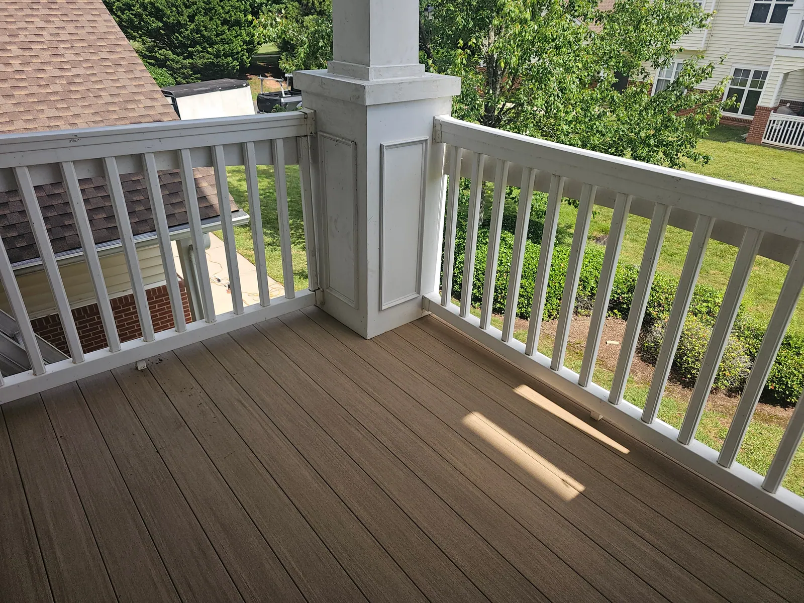 Rebuilt second-story balcony with new decking and white railing