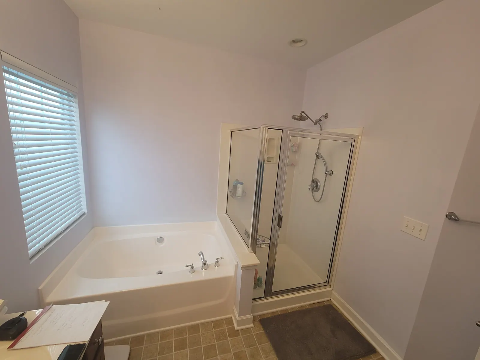Bathroom before a remodel with a built-in garden tub and framed shower