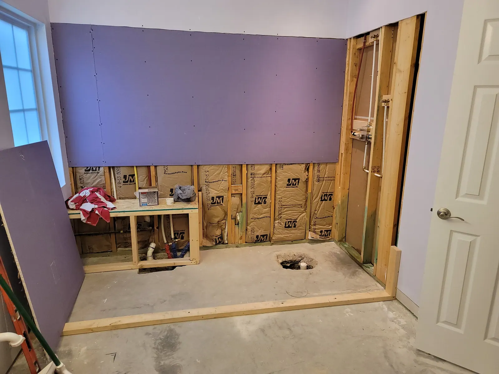 Bathroom opened to the studs with moisture-resistant board going up