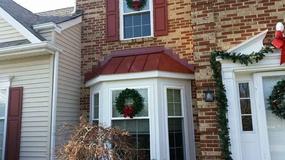 New red standing-seam metal roof over a bay window