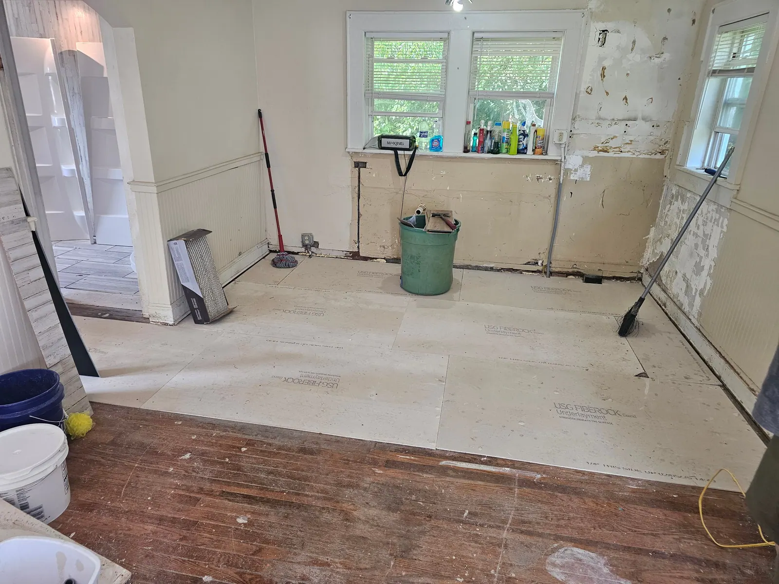 Kitchen cleared out with the subfloor exposed during a remodel