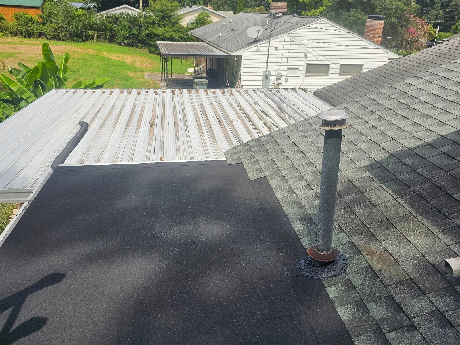 New low-slope roof membrane tied into the shingles with a sealed pipe boot