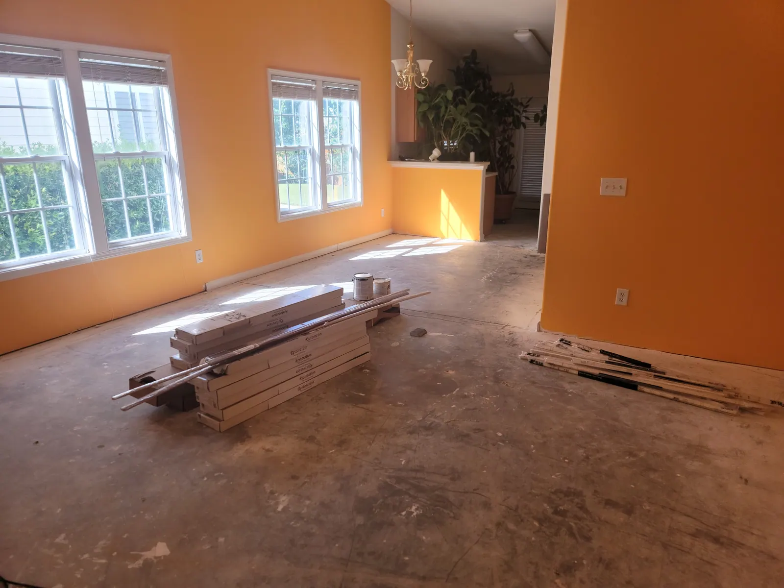 Old floor covering pulled up to the subfloor with new planks staged