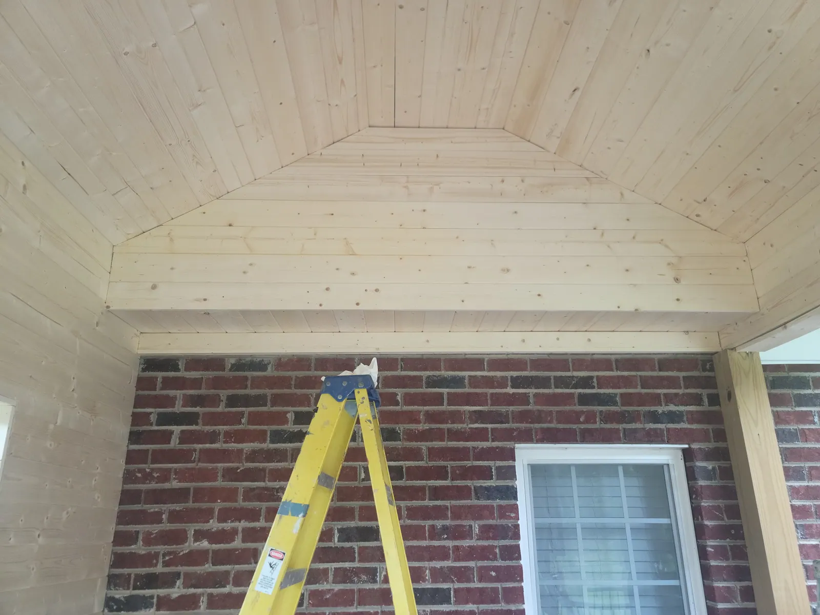 Tongue-and-groove pine ceiling installed over a covered porch