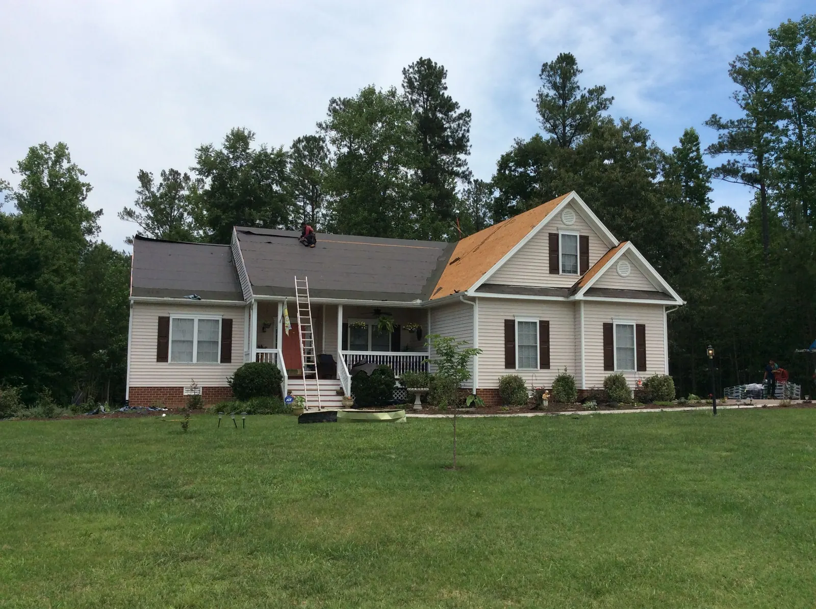 One roof slope stripped to bare decking on a ranch-style home