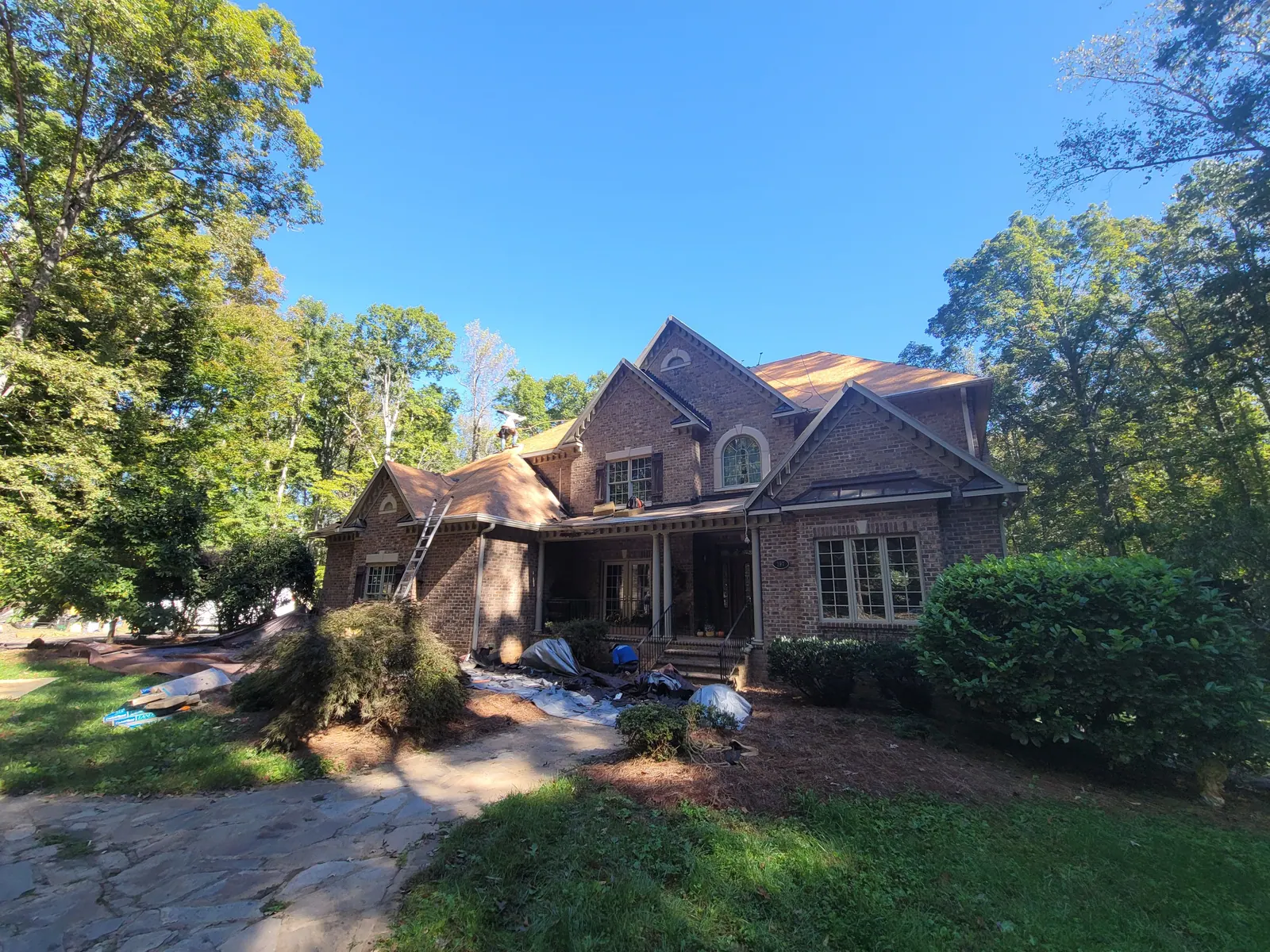 Roof tear-off underway on a large brick home