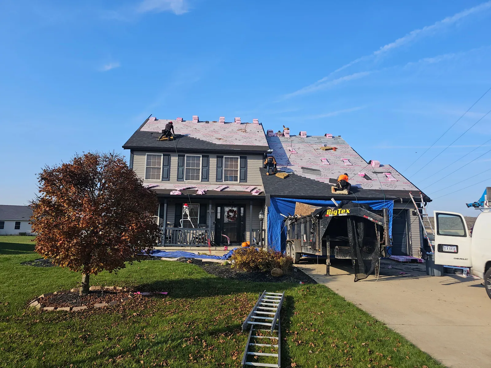Roof covered in synthetic underlayment while the crew installs new shingles